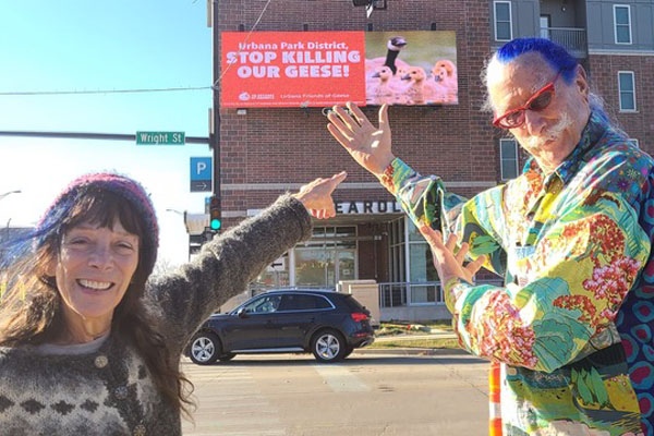 Dr. Susan Parenti and Dr. Patch Adams led the flashmob on Saturday. They are encouraging members of the public to take selfies with the billboard at Wright Street and University Avenue and tag Urbana Parks District on social media. Photo: Derek Busby